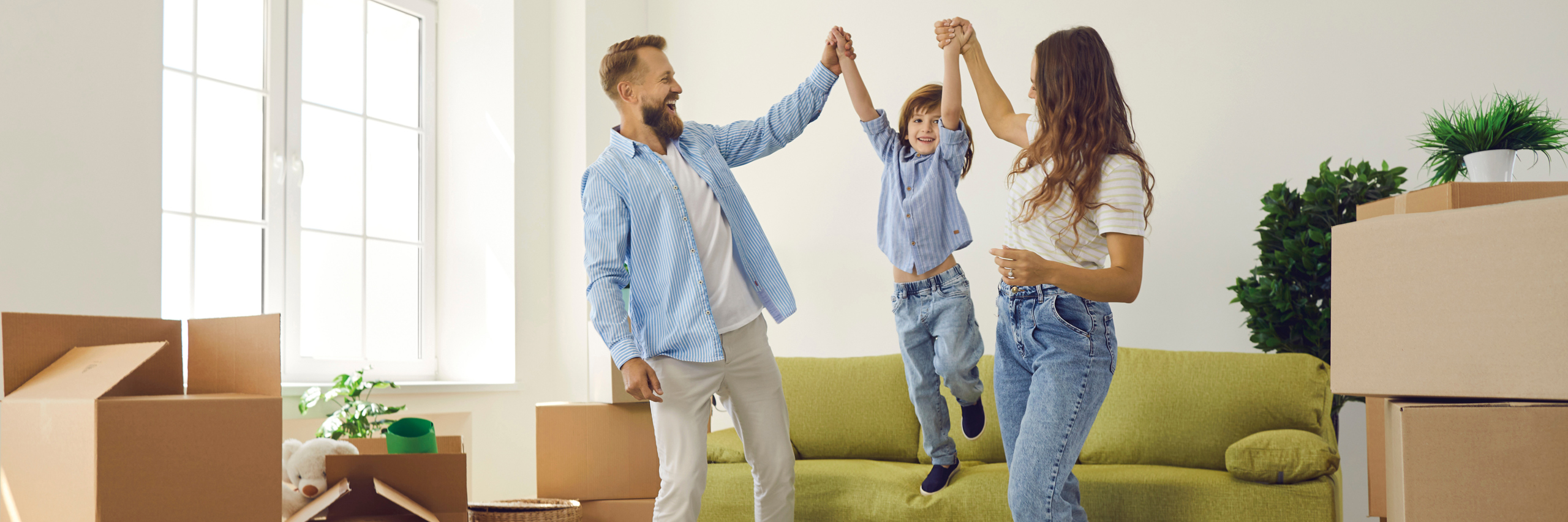 Eine Familie feiert in einem neuen, hellen Zimmer mit Umzugskartons.