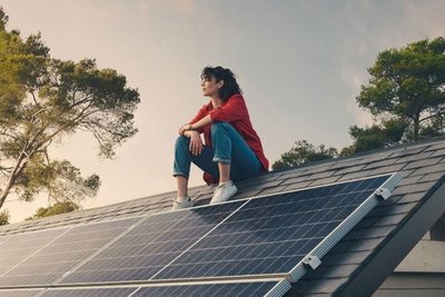 Frau sitzt auf einem Solardach